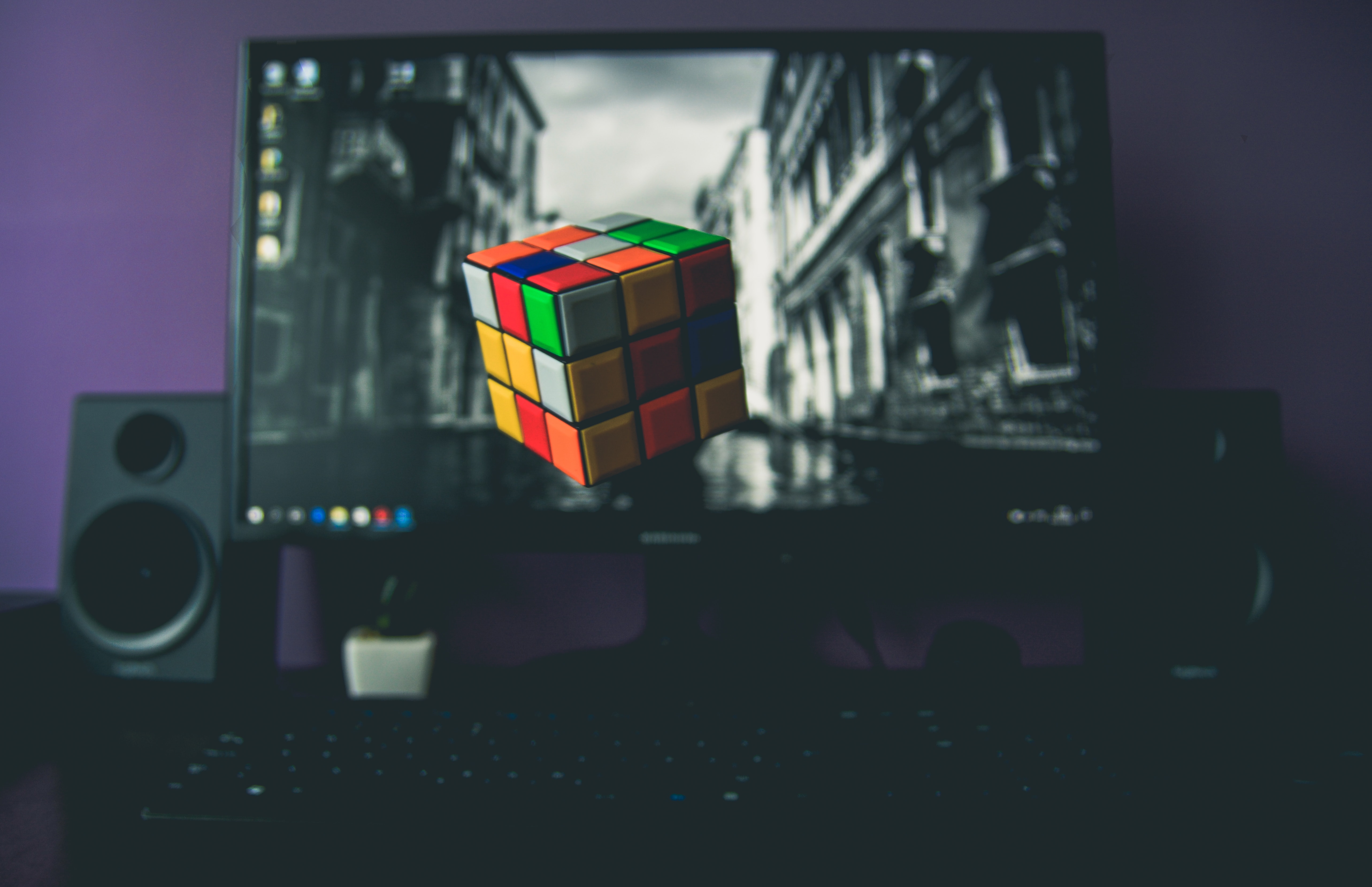 screen image of a coloured cube with a black and white photo background
